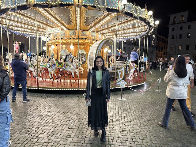 A picture of Sarah in front of a carousel in Piazza Navona